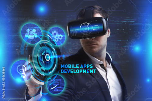 Business, Technology, Internet and network concept. Young businessman working in virtual reality glasses sees the inscription: Mobile apps development