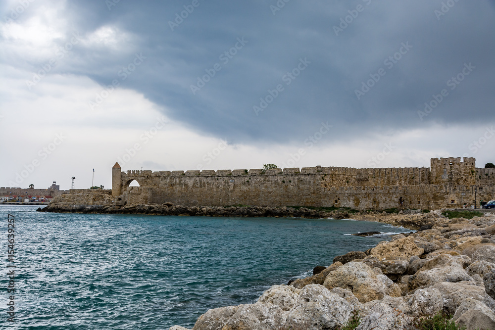 Walls of the Rhodes old town on a stormy day, view from the seaside, Rhodes island, Greece