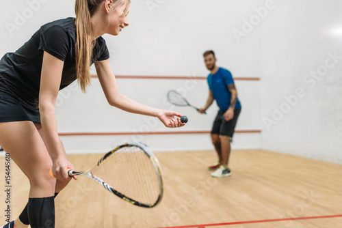 Couple play squash game in indoor training club photo