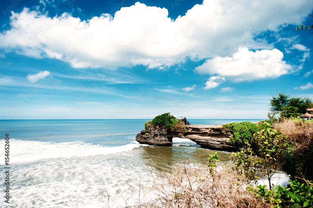 Pura Tanah Lot. Unique hindu temple on a rock in the sea, Bali, Indonesia. dramatic sky with clouds and ocean with waves. Pura Tanah Lot. Unique hindu temple on a rock in the sea, Bali, Indonesia. dramatic sky with clouds and ocean with waves.