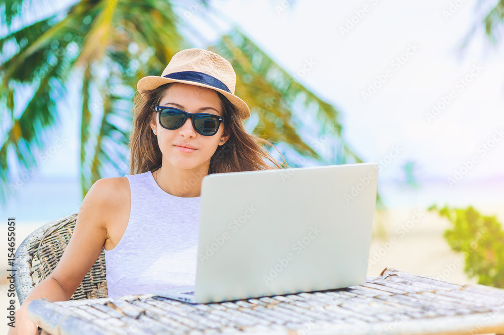 Young woman working in laptop on the beach. Freelance work Young woman working in laptop on the beach. Freelance work