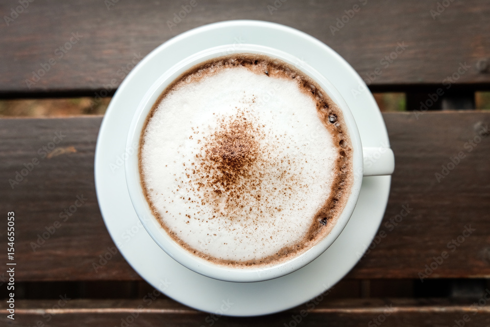 hot cocoa and milk foam on wooden table hot cocoa and milk foam on wooden table