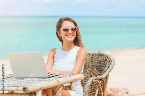 Obraz na płótnie Young sexy woman using laptop on the beach. Freelance work w salonie