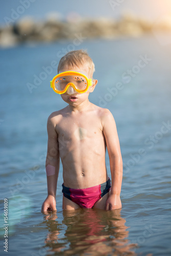 Little boy with snorkel by the sea. Cute little kid wearing mask and flippers for diving at sand tropical beach. Ocean coast.