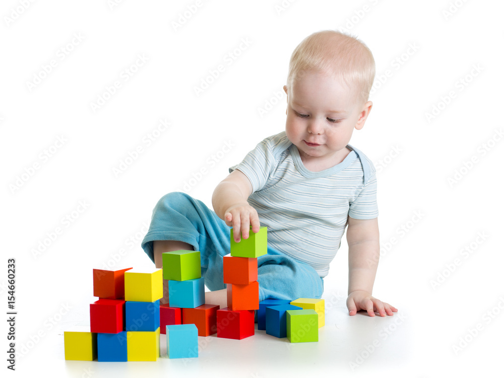 Lovely toddler baby playing with building cubes. Isolated on white. Lovely toddler baby playing with building cubes. Isolated on white.