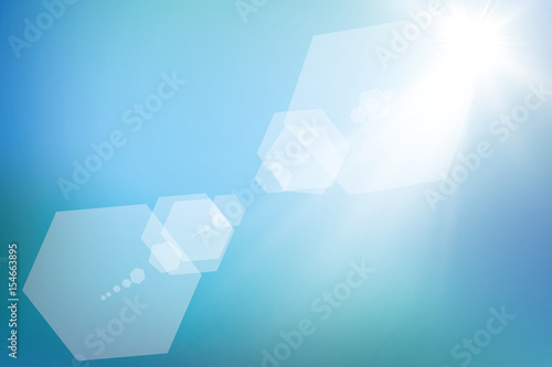 bright sun on blue sky background with lens flare
