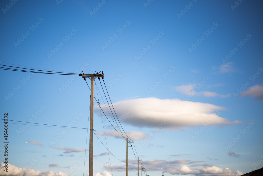 Concrete electric pylon power pole under blue sky