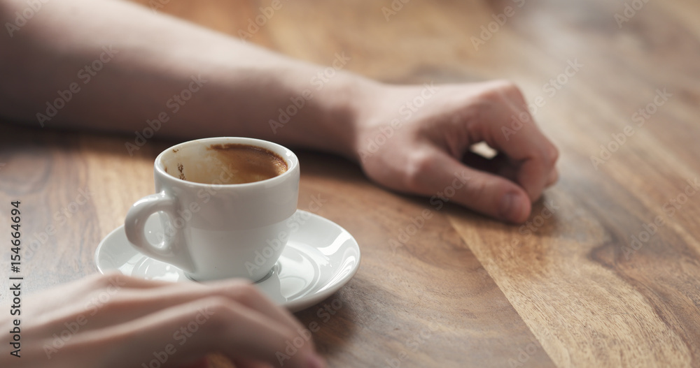 Young man hand with coffee cup waiting tapping fingers sitting at the table Young man hand with coffee cup waiting tapping fingers sitting at the table