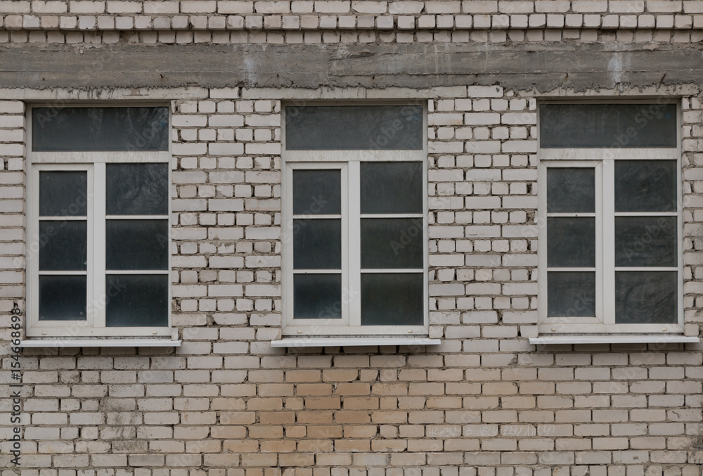 A dirty window in a brick wall.