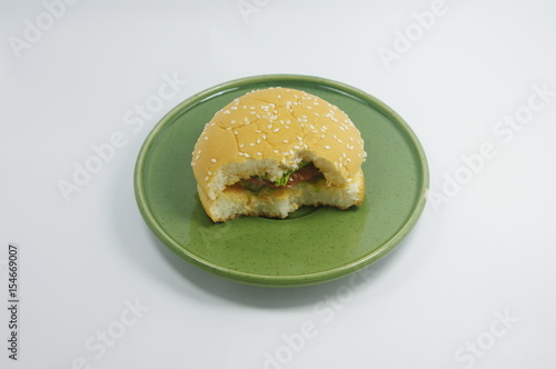 hamburger on small green plate.