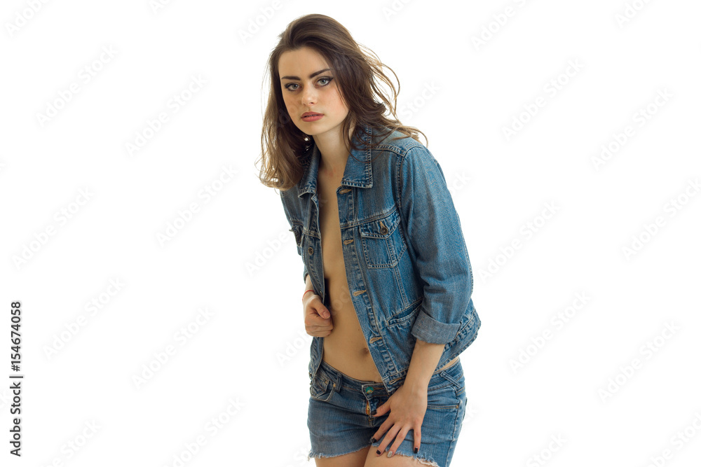Portrait of a beautiful brunette in jeans jacket that looks right and keeps hand collar Portrait of a beautiful brunette in jeans jacket that looks right and keeps hand collar
