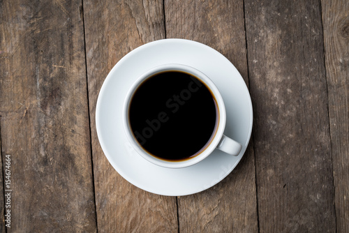 White coffee cup on an old wooden table. Close up