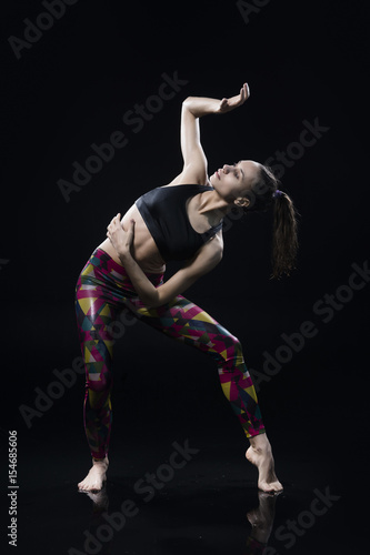 The girl dances on the floor covered with water on a black background © Алексей Торбеев