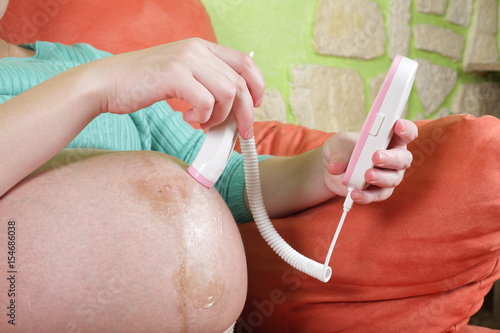 Fotografia, Obraz Pregnant woman with a fetal doppler