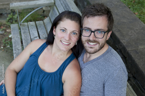 Beautiful young couple snuggle and smile in the park