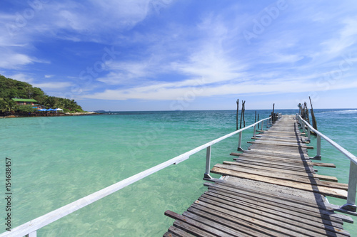 Wood bridge pier on summer tropical sea in blue sky. © amthinkin