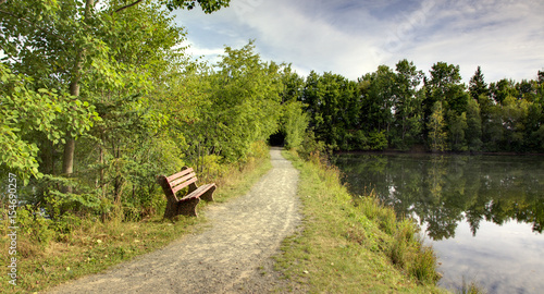 bench and trail at park with lake 