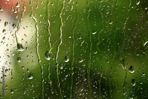 Rain drops on window with green in background