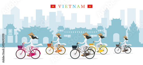 Vietnamese Women with Conical Hat Ride Bicycles, Landmarks Background