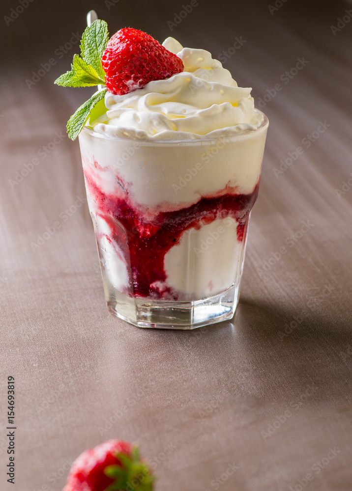 Ice cream with topping and berries in a glass
