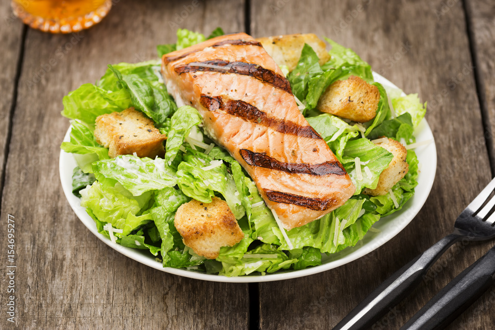Grilled Salmon Caesar Salad on Rustic Wooden Table Grilled Salmon Caesar Salad on Rustic Wooden Table