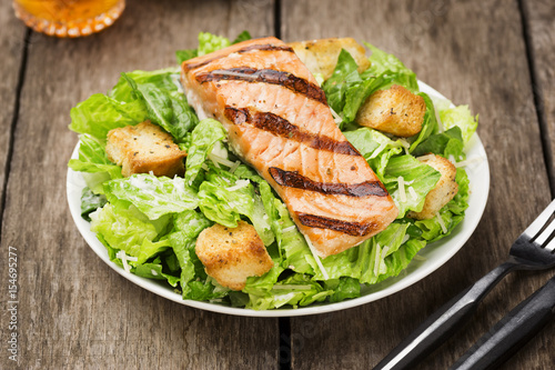 Grilled Salmon Caesar Salad on Rustic Wooden Table