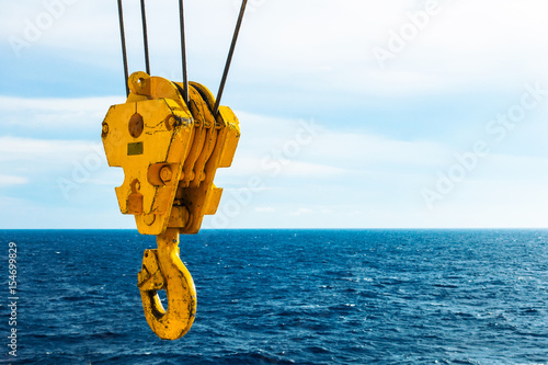 Crane hook in the sea with sky and clouds background on offshore platform