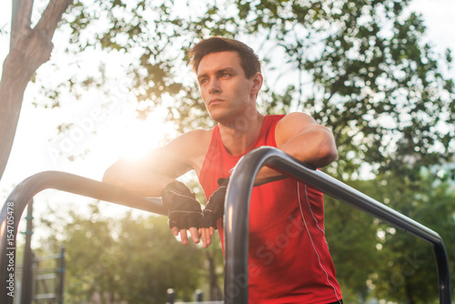 Young athletic man taking a break during working out outdoor.