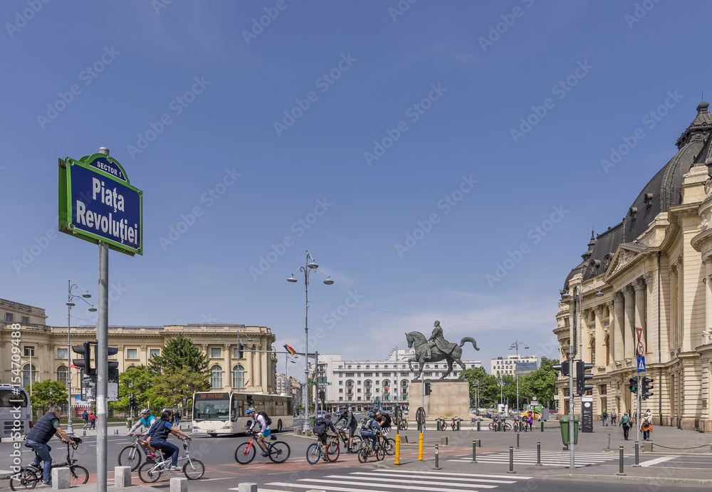 Traffic of bicycles and buses in Revolution Square, historical center of Bucharest, Romania, on a beautiful sunny day