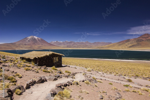 sand path to mountain lake and house with blue sky in atacama chile