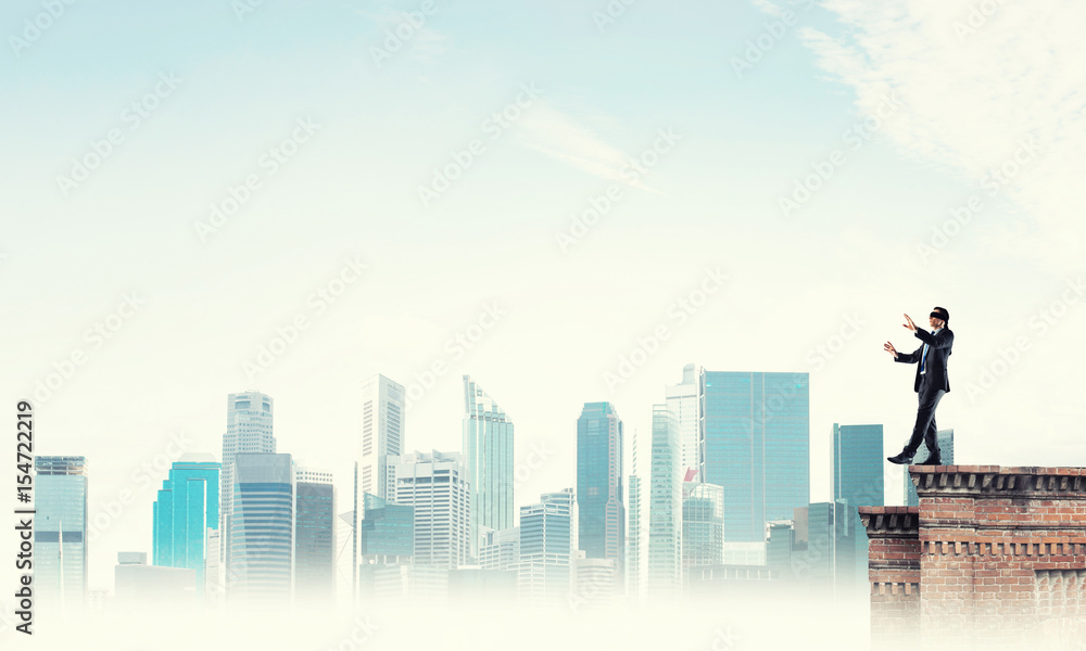 Danger and risk concept with businessman making step from edge Danger and risk concept with businessman making step from edge