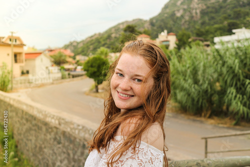 Red hair, beach waves, freckles skin girl smiling in summer trip