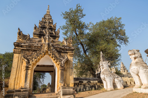 Ornate gate and guardian lion statues at the Maha Aungmye (Aung Mye) Bonzan monastery (also known asn Me Nu Ok Kyaung or Me Nu's Brick Monastery) in Inwa (Ava) near Mandalay in Myanmar (Burma).