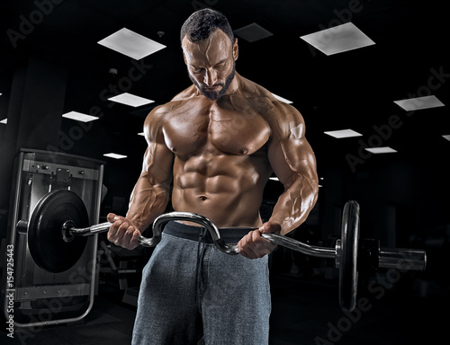 Adult guy bodybuilder posing in gym