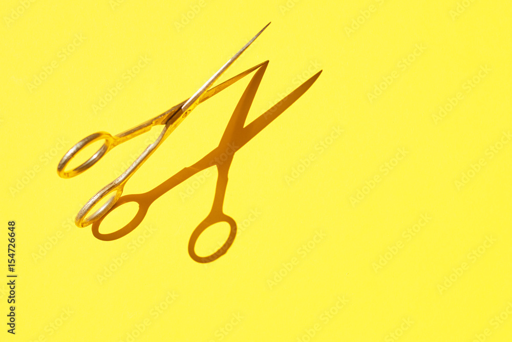 design photo of scissor on vivid yellow background design photo of scissor on vivid yellow background