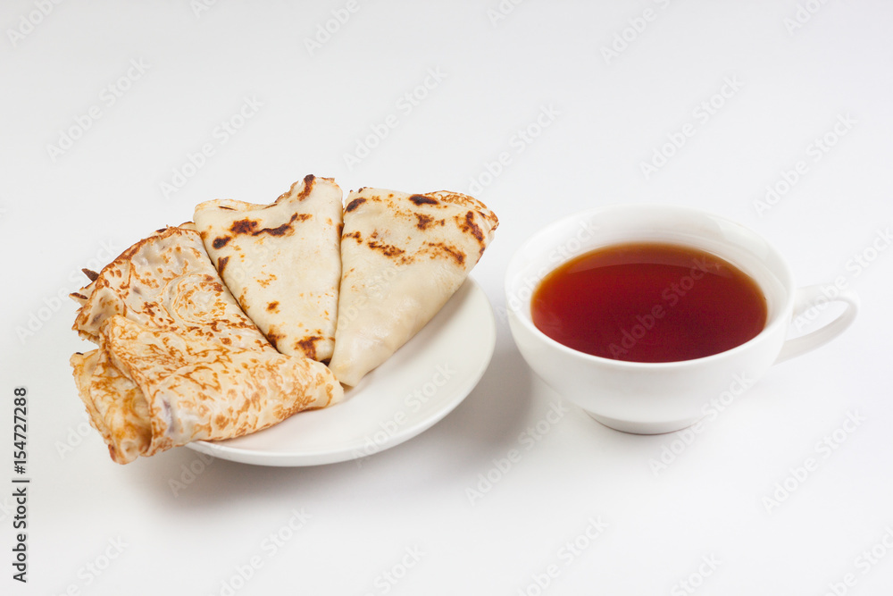 Three pancakes on a plate with a cup of tea Three pancakes on a plate with a cup of tea