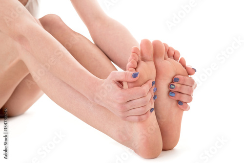 female feet over white background. Woman massaging feet