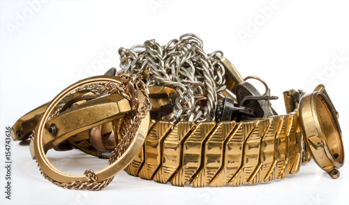 A scrap of gold. Old and broken jewelry, watches of gold and silver are isolated on a white background.