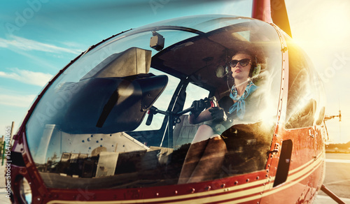 Attractive woman pilot sitting in the helicopter