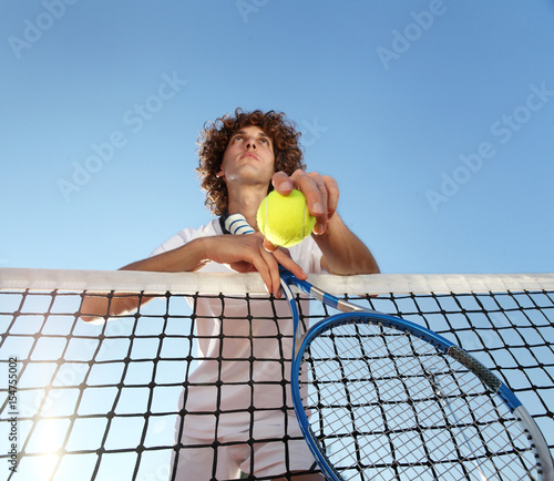 tennis player with racket and ball standing in front of the net © amedeoemaja