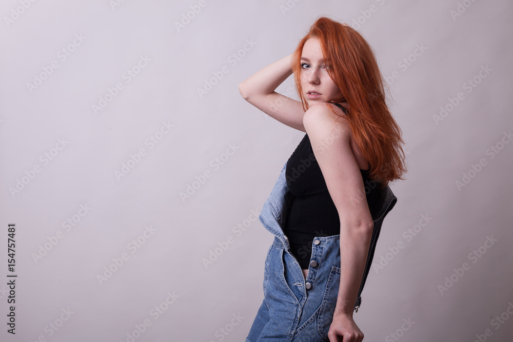 Sensual busty redhead woman in studio photo on gray background. Sexuality and sensuality. Attractive model Sensual busty redhead woman in studio photo on gray background. Sexuality and sensuality. Attractive model