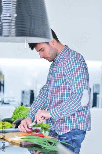 Happy man using digital tablet in kitchen at home