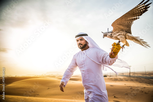 Arabic man in the desert with his hawk photo