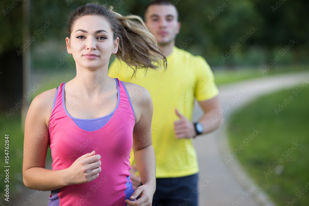 Fototapeta premium Couple stretching before jogging at the bench in the park