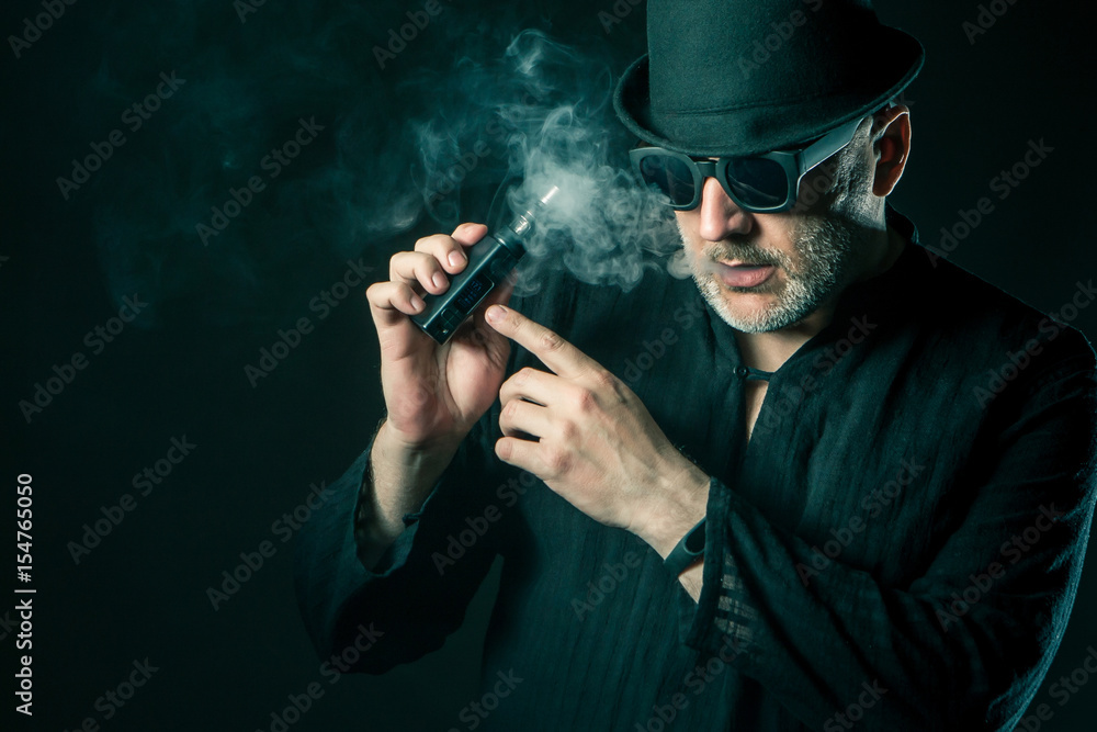 man smoking e-cigarette wearing sunglasses man smoking e-cigarette wearing sunglasses
