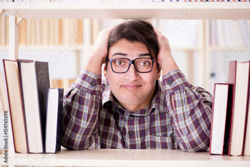 Young student looking for books in college library