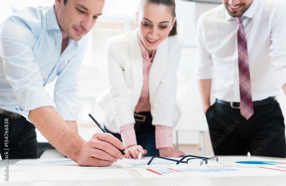 Obraz premium Business people analyzing financial data - glasses on graph, symbol for focus and detail