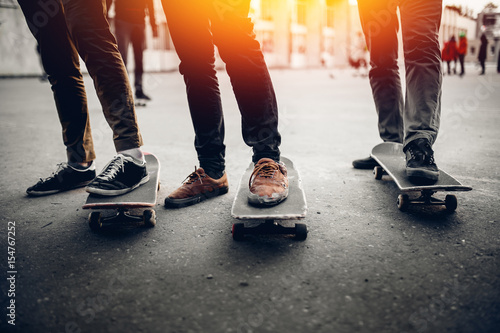 Fotografie Group of friends skateboarders rest on the street and skateboard