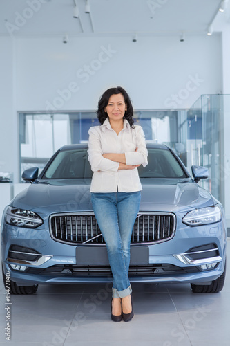 Attractive woman customer choosing a car at the dealership