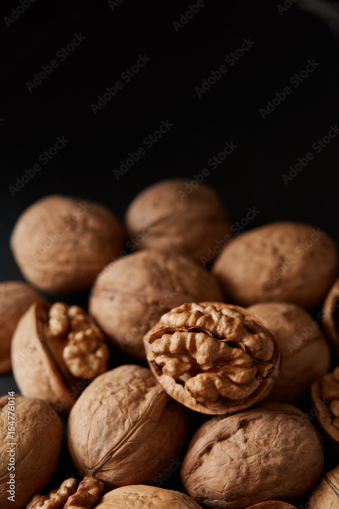 Walnuts and kernels on a black backdrop Walnuts and kernels on a black backdrop